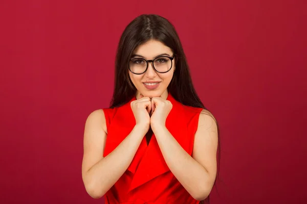 beautiful young woman with makeup in a red suit on a red background