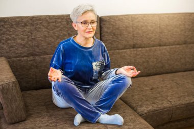 Yoga pozu veren kısa saçlı şık bir kadın.