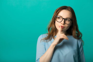  Yeşil arka planda, el hareketleriyle güzel, genç bir kadın.