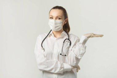  Beyaz bir arka planda tıbbi maske takan güzel genç bir kadın.