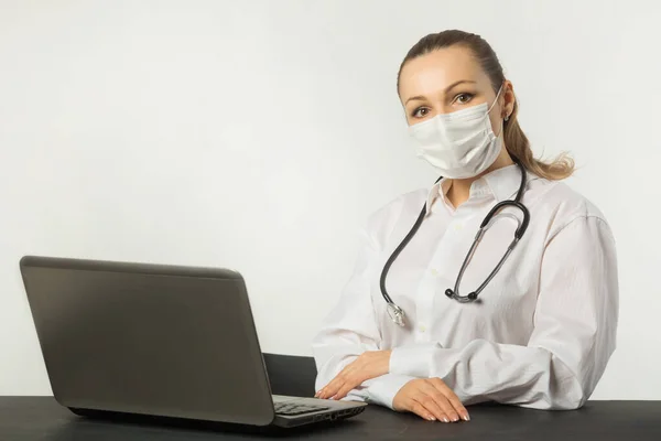 stock image  beautiful young woman in medical face mask with laptop