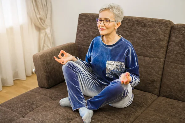 Yoga pozu veren kısa saçlı şık bir kadın.
