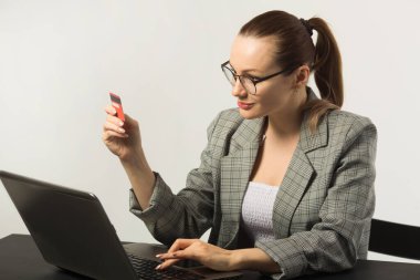 Masada dizüstü bilgisayarı beyaz arka planda olan becerikli genç bir kadın.