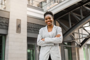 Binanın yanında ceketli güzel bir Afrikalı kadın var.