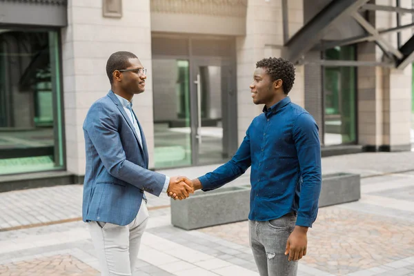 Binanın yanında iki yakışıklı Afrikalı var.