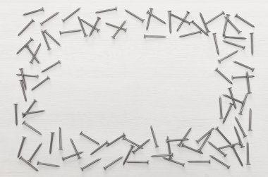 Beyaz ahşap tahta yüzey arka plan kopya alanı ile üzerinde dağınık çivi çerçeve yaptı. İnşaat kavramı arka plan.