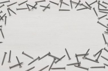 Beyaz ahşap tahta yüzey arka plan kopya alanı ile üzerinde dağınık çivi çerçeve yaptı. İnşaat kavramı arka plan.