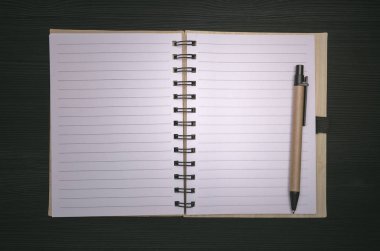 Not Defteri ile boş kağıt sayfa üzerinde siyah ahşap tahta arka plan izole kopya alanı ile. Yapılacaklar listesi için. İpuçları.