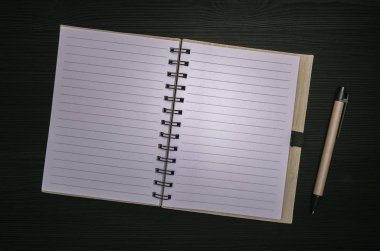 Not Defteri ile boş kağıt sayfa üzerinde siyah ahşap tahta arka plan izole kopya alanı ile. Yapılacaklar listesi için. İpuçları.