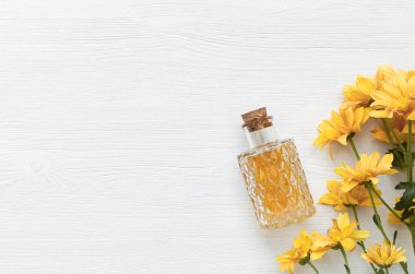 Krizantem papatya çiçek esans tentür şişe beyaz ahşap masa arka plan kopya alanı ile. Bitkisel ilaç.