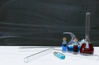 Renkli sıvı kimyasal şişeler ve şişeleri kopya alanı okul yazı tahtası zemin üzerine. Eğitim kavramı arka plan. Kimya veya biyoloji ders.