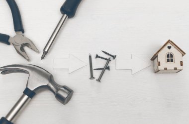 Ev inşaat kavramı arka plan kopya alanı ile. Çekiç ve çivi ve Beyaz ahşap masa kurulu kağıt oyuncak ev.