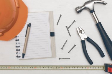 İnşaat kavramı arka plan kopya alanı ile. Boş not defteri boş kağıt sayfası, kalem ve masanın üzerine çivi çekiç ile. İnşaat hileler.