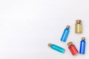 Kopya alanı, üstten görünüm ile beyaz ahşap masa arka plan üzerinde renkli esans tentürler kümesi. Alternatif Tıp.