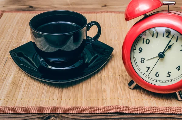 红色闹钟和杯黑咖啡在办公桌上的背景 咖啡打破概念 — 图库照片