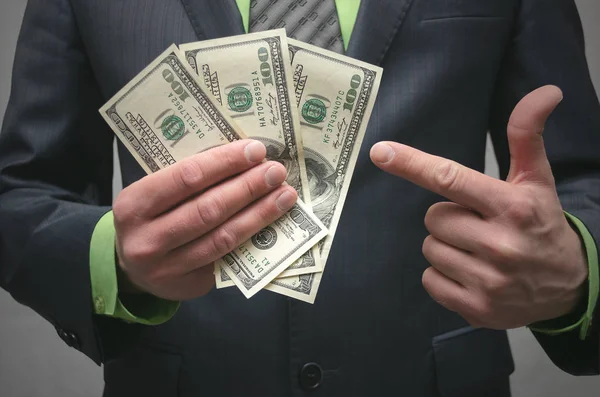 Деловой Человек Держит Руках Долларовые Деньги Показывает Указательным Пальцем Дай — стоковое фото