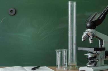 Öğretmen, öğrenci, biyolog veya kimyager Resepsiyon tablo. Eğitim arka plan. Eğitim kavramı. Mikroskop, şişe, şişe, kabı ve masanın üzerine kalem ile kitap.