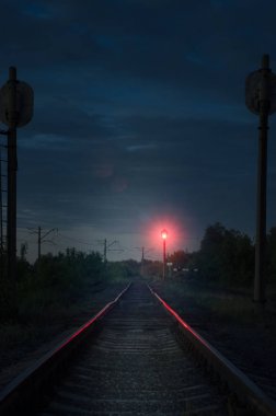 Boş demiryolu ve trafik lambasından gece.