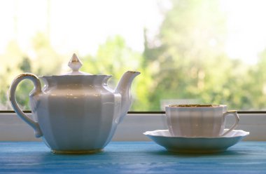 Kupası ve çaydanlık pencerenin önünde.