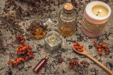 Bitkisel Tıp kavramı. Alternatif Tıp. Şifalı vahşi rowan berry ve elma ağacı berry otlar ve uçucu yağ çuval bezi çul arka plan üzerinde kuru.