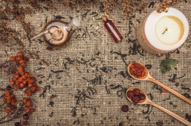 Bitkisel Tıp kavramı. Alternatif Tıp. Şifalı vahşi rowan berry ve elma ağacı berry otlar ve uçucu yağ kopya alanı çuval bezi çul zemin üzerine kuru.