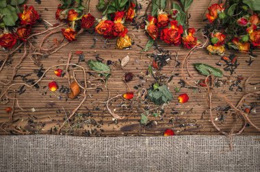 Dağınık otlar ve kuru çiçek bitkisel ilaç kavramı arka plan üzerinde kahverengi ahşap masa bırakır.