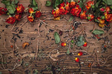 Dağınık otlar ve kuru çiçek bitkisel ilaç kavramı arka plan üzerinde kahverengi ahşap masa bırakır.