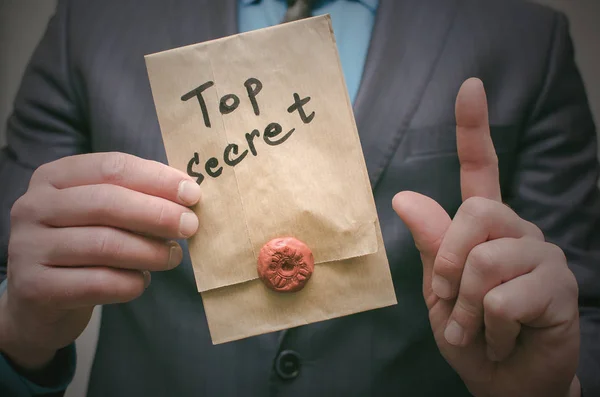 Top secret documents presentation concept. Top secret message in detective spy agent hands. Confidential dossier information. Super important information.