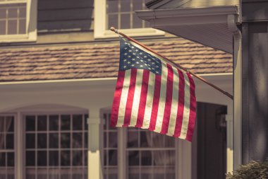 Amerikan bayrağı tipik Amerikan evinin önünde. Fosus bayrağı
