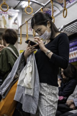 PARIS, FRANCE - CIRCA 2013: Paris metrosu meşgul insanlar ve kadın telefonuna bakıyor