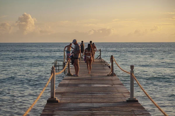 People on the pier at sunset — Stock Photo, Image