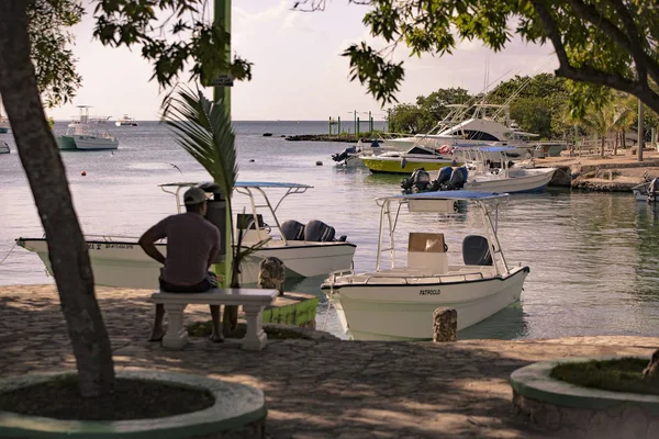 Hombre sentado en el banco mira el mar desde el puerto de Bayahibe 2 — Foto de Stock