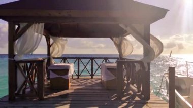 Dominicus sahilindeki iskelede güneşli yataklar ve çırpınan çadırlarla