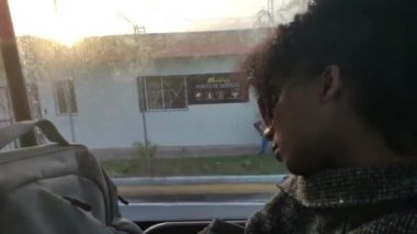 Günbatımı saatinde bir kız pencereden dışarı bakar.