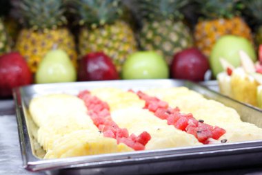 Büfede tatlı olarak kullanılan meyve dilimleriyle dolu tepsiler.