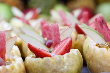 Büfede tatlı olarak kullanılan meyve dilimleriyle dolu tepsiler.