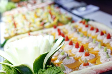 Büfenin içinde bir tepsi kek ve pasta dilimleri.