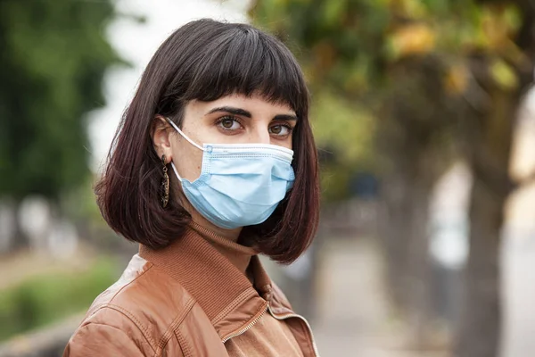 İtalya 'da karantina sırasında açık havada tıbbi maskeli bir kızın portresi.