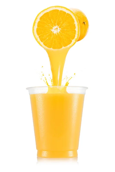 Апельсиновый сок выливается из фруктов в пластиковую чашку — стоковое фото