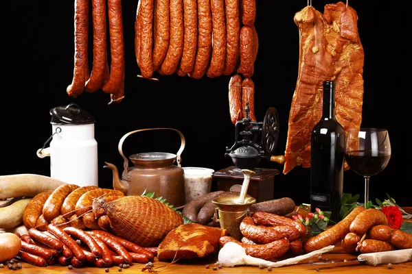 Mesa de campo com carne e vinho sobre fundo preto — Fotografia de Stock