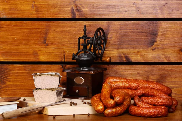 Saucisse et rôti sur une table en bois avec un moulin à café — Photo