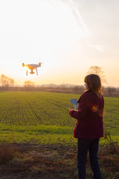 Menina com drone voando ao pôr do sol — Fotografia de Stock
