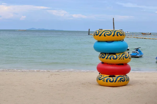 Zásobník barevné plovoucí kruhy na pláži, záchranným kruhem, gumový kroužek, plavání trubky — Stock fotografie