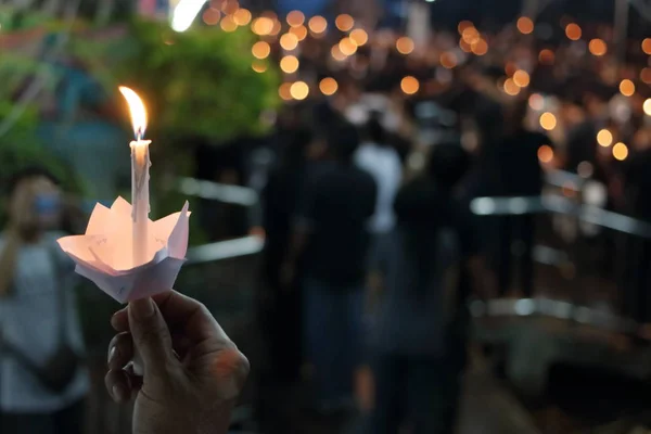 Hand des Mannes halten Kerzenflamme Licht in der Nacht mit Bokeh Hintergrund — Stockfoto