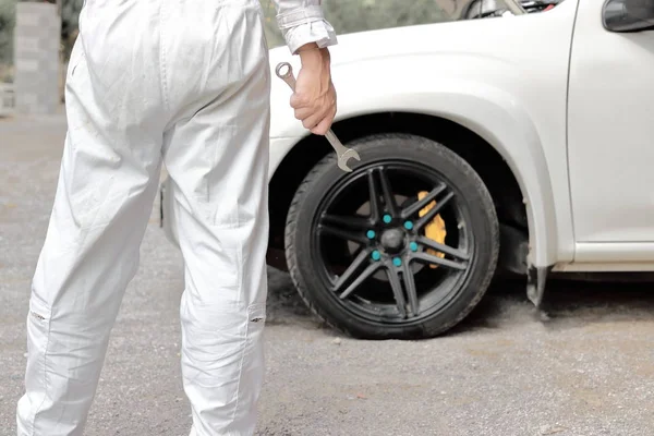 Mecânico automotivo confiante em chave de retenção uniforme em suas mãos pronto para reparar o motor do carro . — Fotografia de Stock