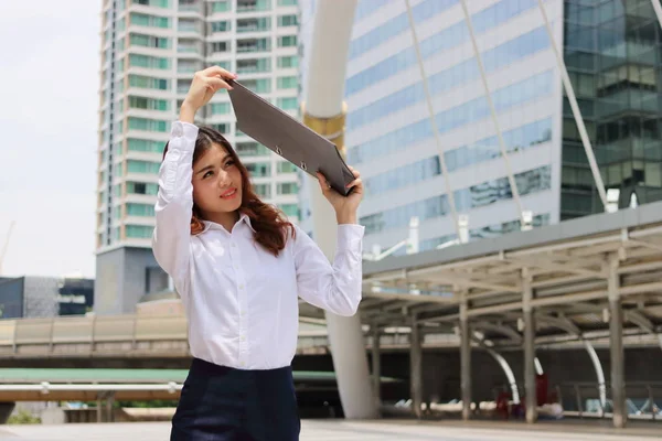 Портрет привлекательной деловой женщины поднимает папку офисных документов, чтобы оградить от солнечного света . — стоковое фото