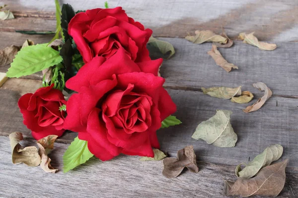 Красивый искусственный букет красных цветов на старой деревянной доске на фоне пространства для копирования. Love and romance Valentine 's day concept — стоковое фото