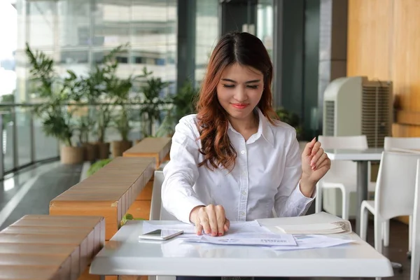 Портрет молодой привлекательной азиатской деловой женщины, смотрящей на свою работу в кафе в перерыве . — стоковое фото