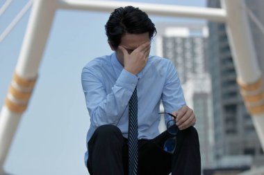 Hayal kırıklığına uğramış genç Asya iş adamı önden görünümü gözlük alır ve gözlerini kapat. o duygu zorlanma ya da çalıştı ve baş ağrısı.