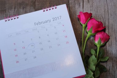 Tarihi 2017 Şubat 14 Sevgililer günü ve ahşap tahta arka planda güzel kırmızı güller ile takvim yakın